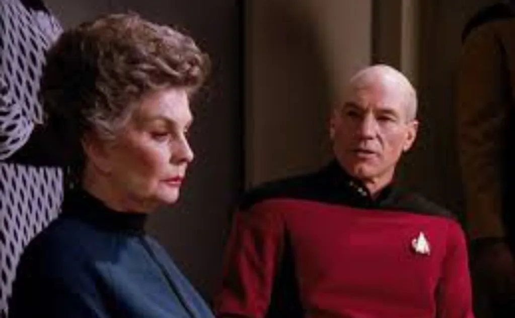 Picard glaring, seated beside Admiral Norah Satie during the hearing in "The Drumhead".