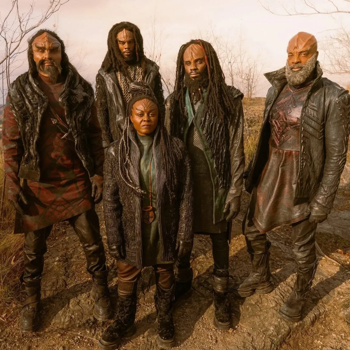 Jay-Den and his Klingon family, in dark leathers, standing together on rocky ground, from Starfleet Academy.